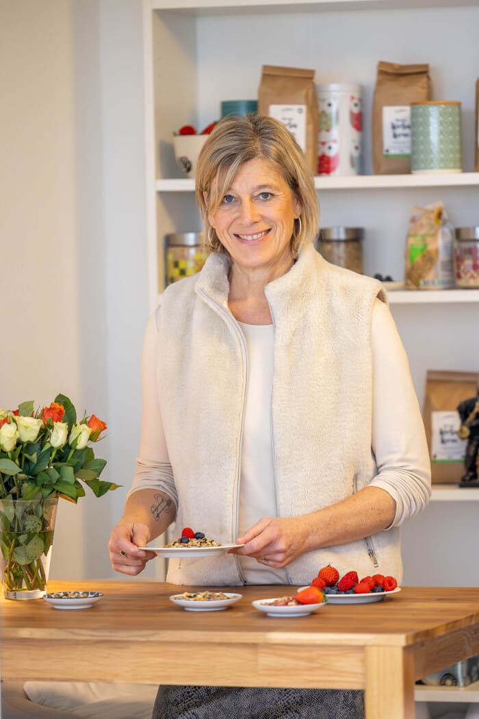Isabel Kühlborn, Inhaberin von natürlich drauf, hält eine Frühstücksschale mit Müsli Topping in der Hand